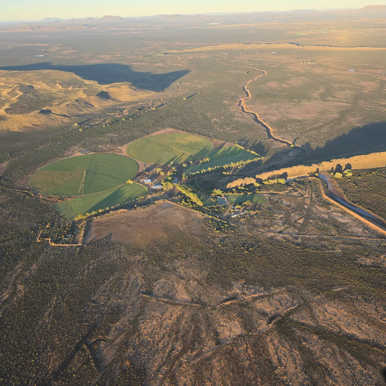 A Karoo farm with green irrigated fields in a dry valley, seen from the paramotor on Day 3
