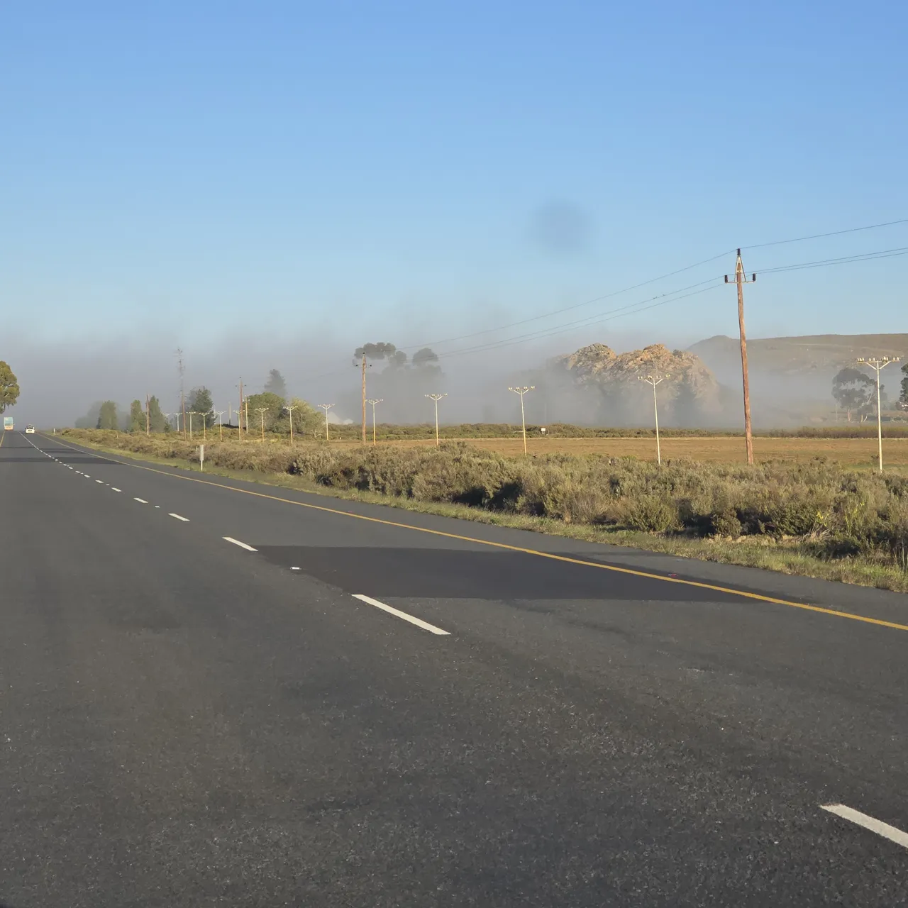 Low mist over a road and fields on Sunday morning